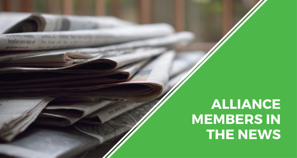Alliance members in the news text graphic with picture of newspapers.